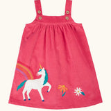 Frugi agatha organic cotton pink corduroy pinafore child's dress with unicorn applique and rainbow and flower details along the hemline.