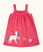 Frugi agatha organic cotton pink corduroy pinafore child's dress with unicorn applique and rainbow and flower details along the hemline.
