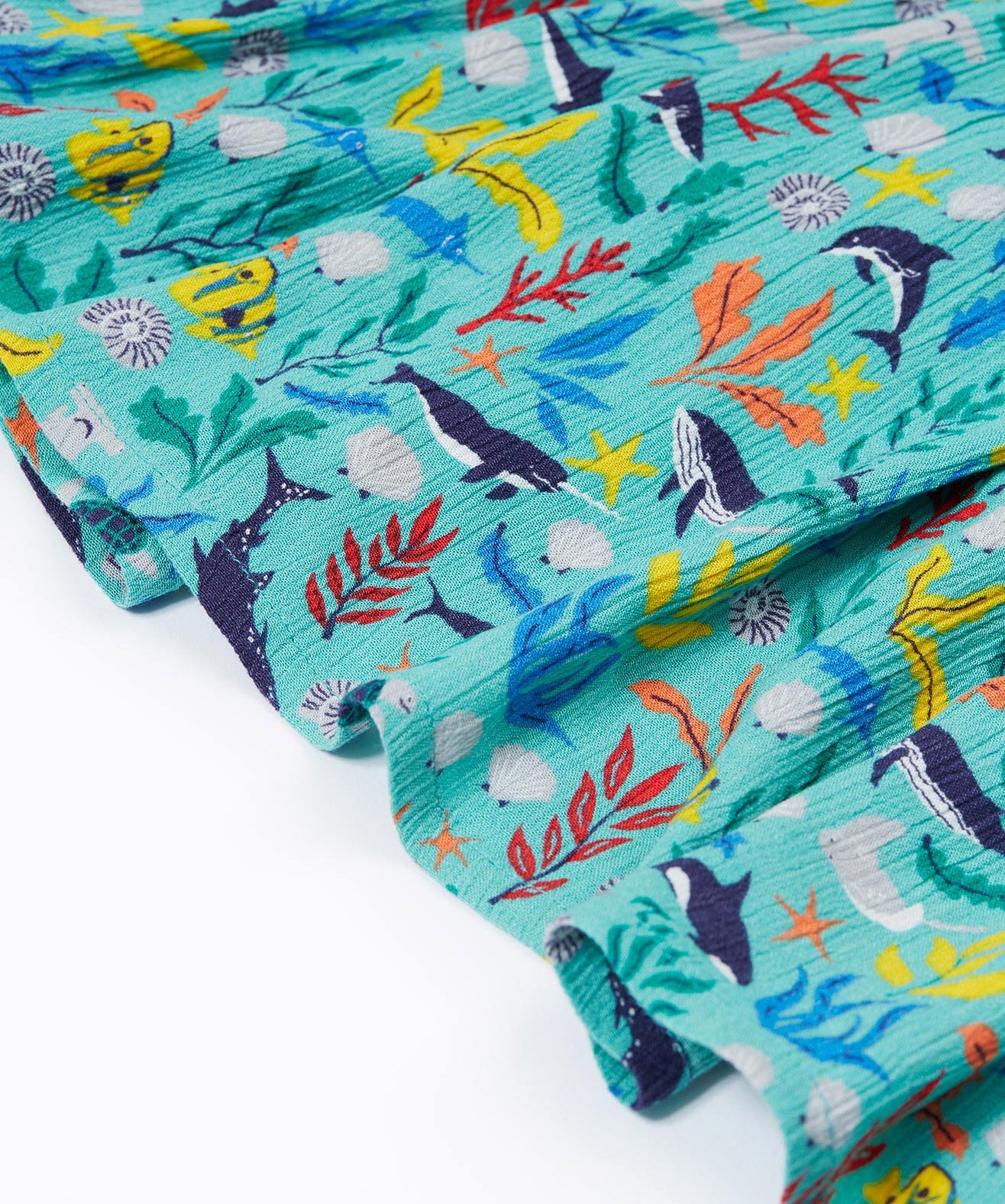 A close up of Frugi Alani Midi Dress, featuring a Sea Life print which includes different sea animals and colourful seaweed and coral on a mint background.