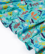 A close up of Frugi Alani Midi Dress, featuring a Sea Life print which includes different sea animals and colourful seaweed and coral on a mint background.