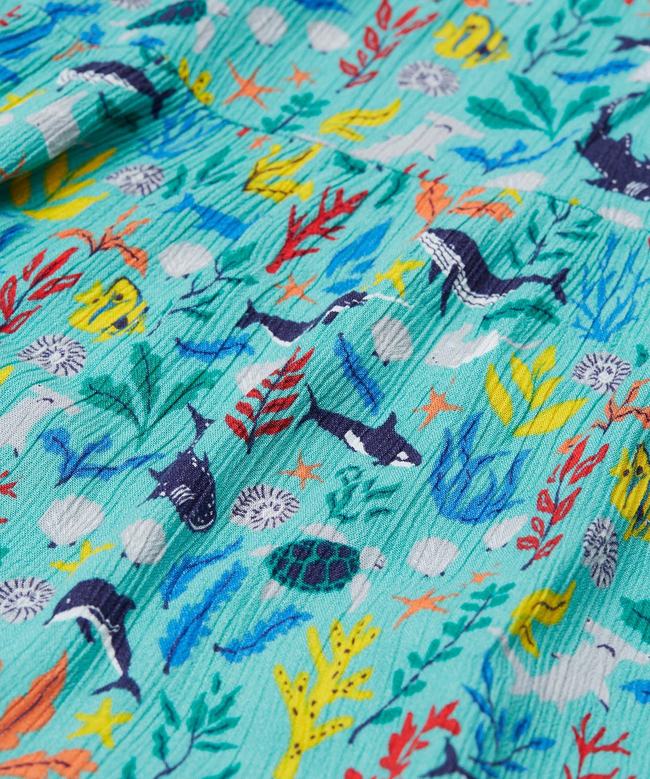 A close up of Frugi Alani Midi Dress, featuring a Sea Life print which includes different sea animals and colourful seaweed and coral on a mint background.