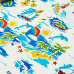 Close-up of the Frugi Aloha Organic Cotton Dungarees, featuring a colourful tropical beach print with dolphins, rainbows and sailing boats.
