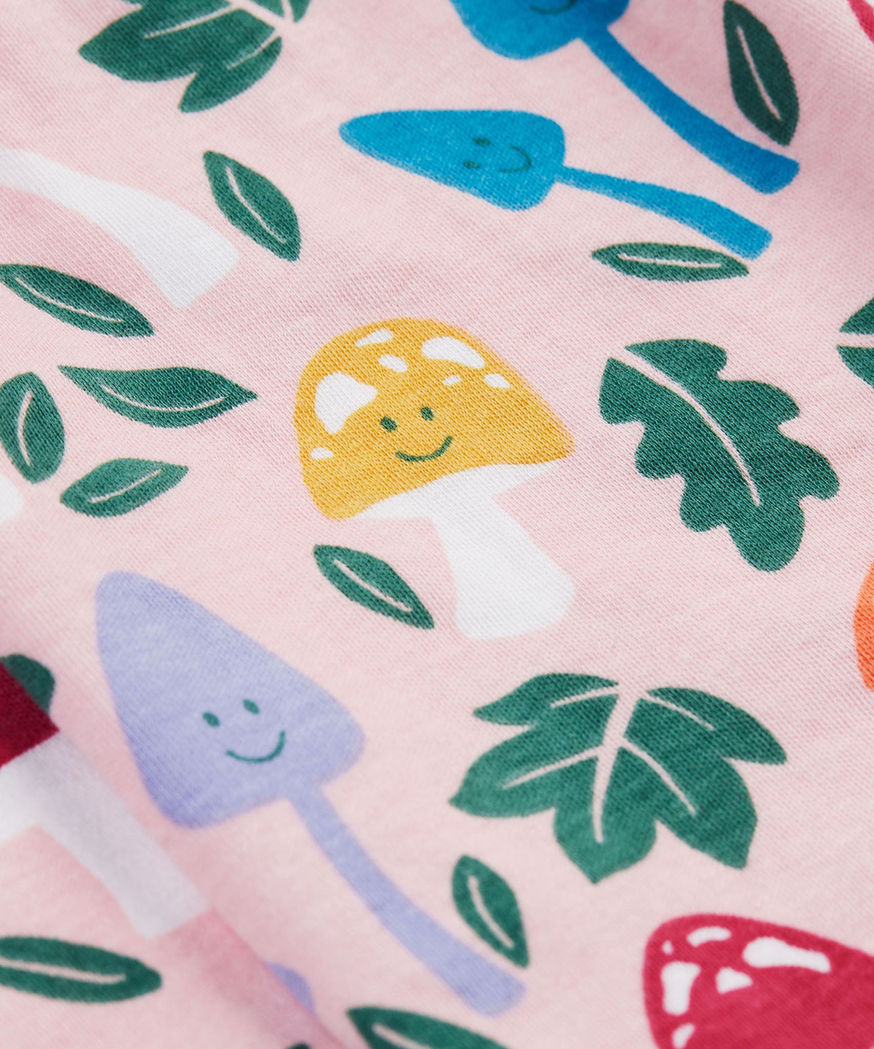 A close up of the Frugi kids pelican fun-guys amelia dress showing the playful mushroom print detail on pink organic cotton fabric.