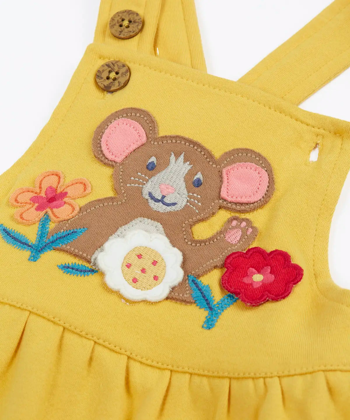 Close up of the mouse and flowers applique on the front of the Frugi Ania bumblebee yellow organic cotton pinafore dress.