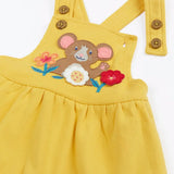 Close up of the front of the Frugi Ania bumblebee yellow pinafore dress with mouse and flowers applique on the front.
