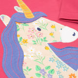 A super close up of teh unicorn applique on the front of the Frugi Rose Pink  Unicorn Anna Circular Organic Cotton Top. A pink coloured long sleeved top with a floral print unicorn applique on the front. This top is a part of a wide range of organic cotton clothing for children available here at Babipur. 