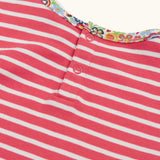 Close up of the popper closure on the back of the Frugi Archer horse and cat applique top in a pink rhubarb Breton stripe .