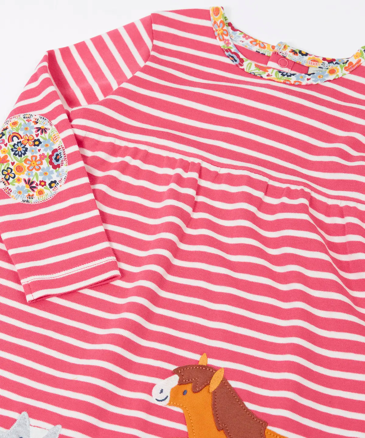 Close up of the floral neckline trim and elbow patch on the Frugi archer dress in rhubarb pink Breton stripes with horse and cat pals appliques along the hemline.
