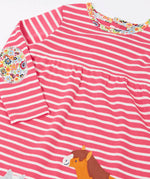 Close up of the floral neckline trim and elbow patch on the Frugi archer dress in rhubarb pink Breton stripes with horse and cat pals appliques along the hemline.