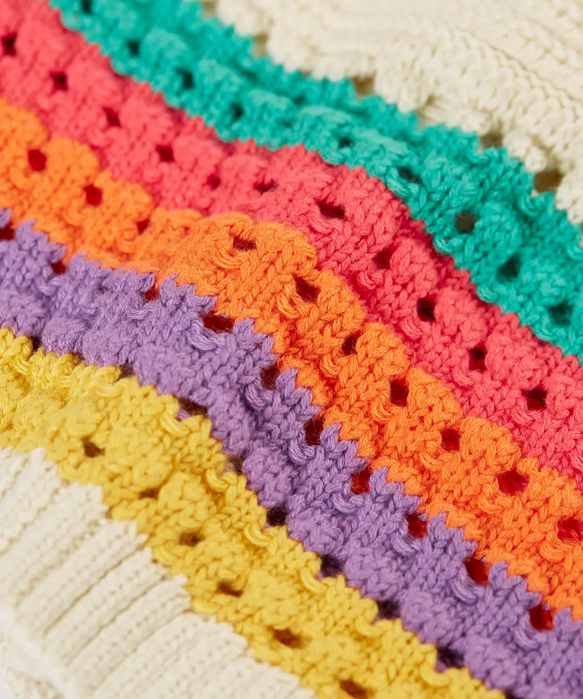 Close up of rainbow stripes on the of the Frugi aurora collar cardigan in natural cream.