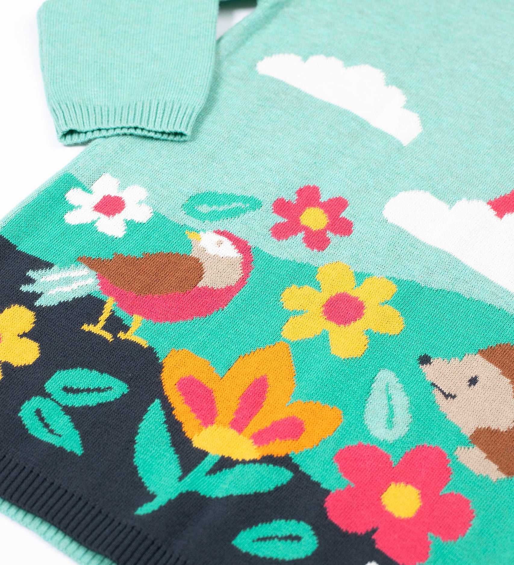 A close up of the design on the Frugi ava blue marl rainbow knitted children's dress.