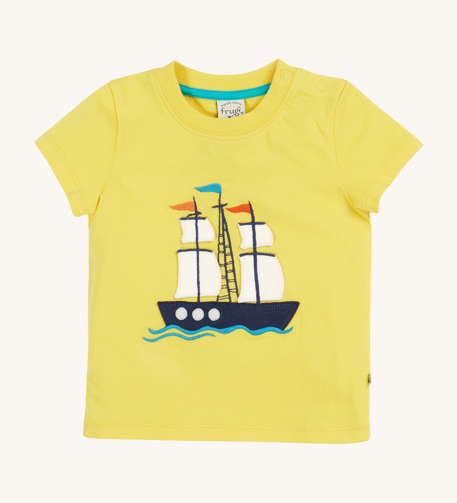 Frugi Avery Applique T-Shirt in Welly Yellow laid flat, with a Tall Ship embroidered design in the centre.