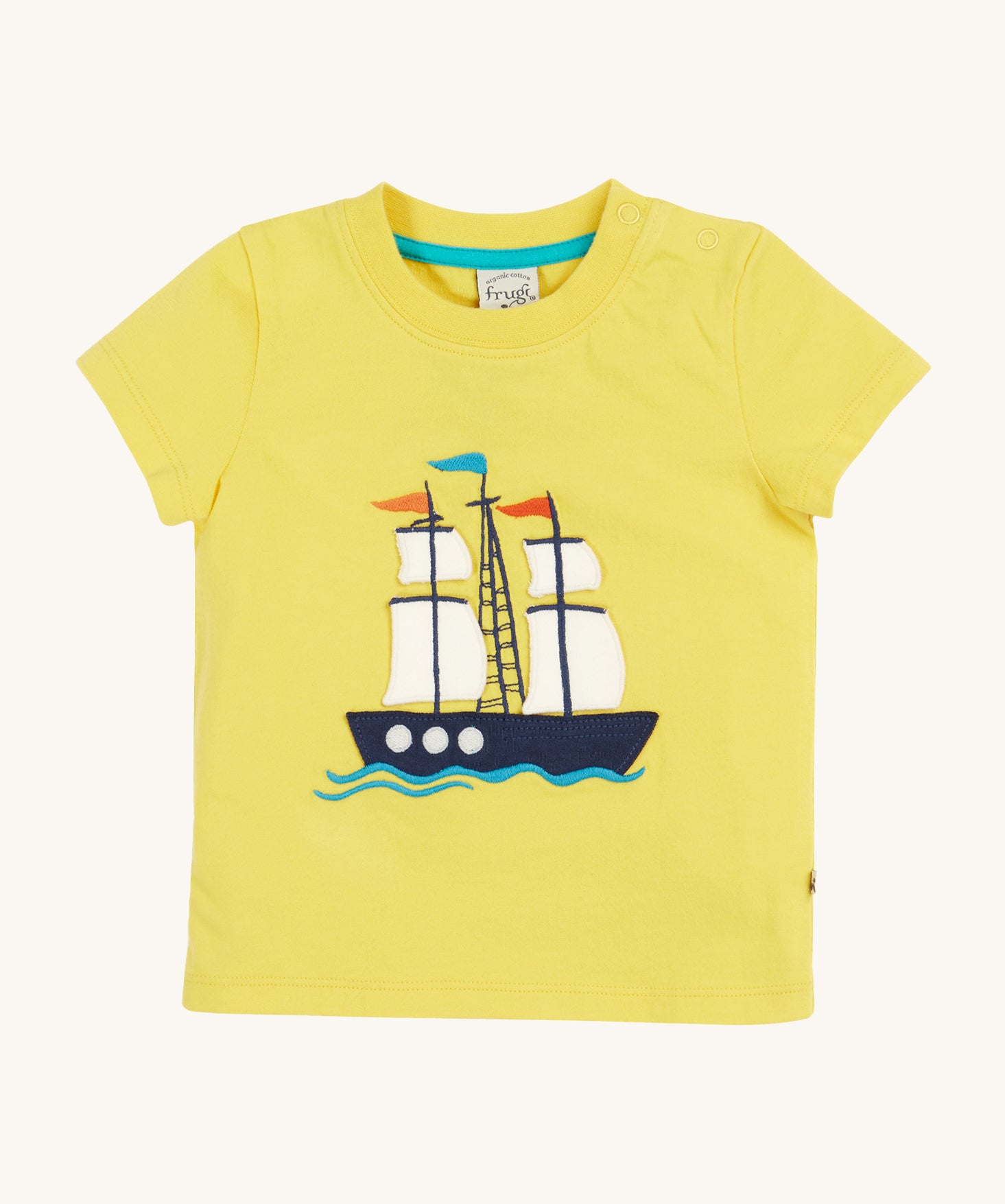Frugi Avery Applique T-Shirt in Welly Yellow laid flat, with a Tall Ship embroidered design in the centre.