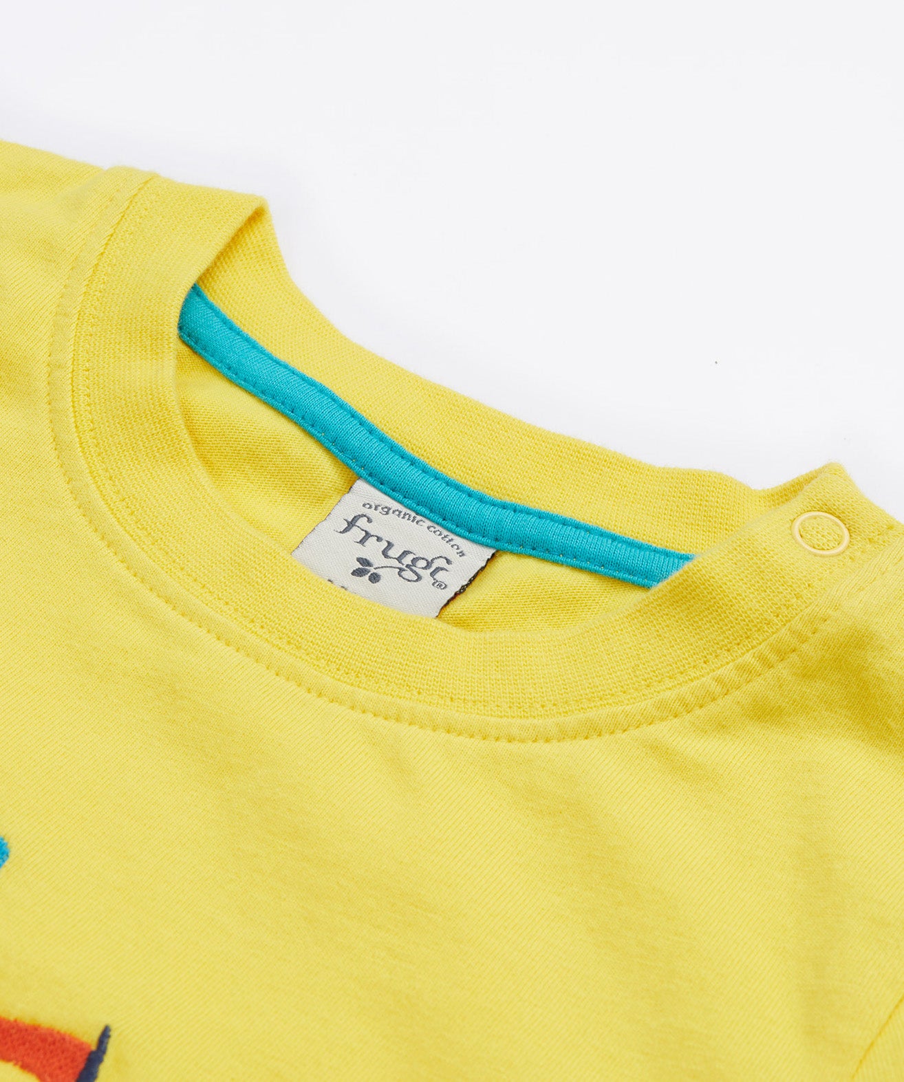 A close up of A close up of Frugi Avery Appligue T-Shirt in Welly Yellow's embroidered collar.