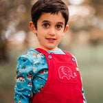 A child wearing teh red cord Frugi Babipur Dungarees showing a close up of the elephant applique detail on the front pocket. The child is wearing the Frugi Dan Y ser top underneath. 