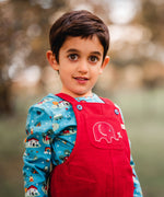 A child wearing teh red cord Frugi Babipur Dungarees showing a close up of the elephant applique detail on the front pocket. The child is wearing the Frugi Dan Y ser top underneath. 