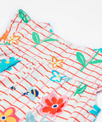 Close up of the Frugi baby Lula paint a floral playsuit. Showing the back popper fastener detail on white and red check organic cotton fabric.