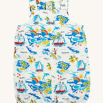 Frugi Aloha Organic Cotton Dungarees laid flat, showing a vibrant all-over tropical print with sailing ships, dolphins, rainbows, palm trees, surfers, and beach motifs on a white background, featuring front pocket and popper fastenings.