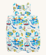 Frugi Aloha Organic Cotton Dungarees laid flat, showing a vibrant all-over tropical print with sailing ships, dolphins, rainbows, palm trees, surfers, and beach motifs on a white background, featuring front pocket and popper fastenings.