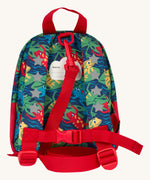 The back of the Frugi little adventures be hoppy backpack showing the reflective stars on the shoulder straps and the red rein clipped to the top of the bag