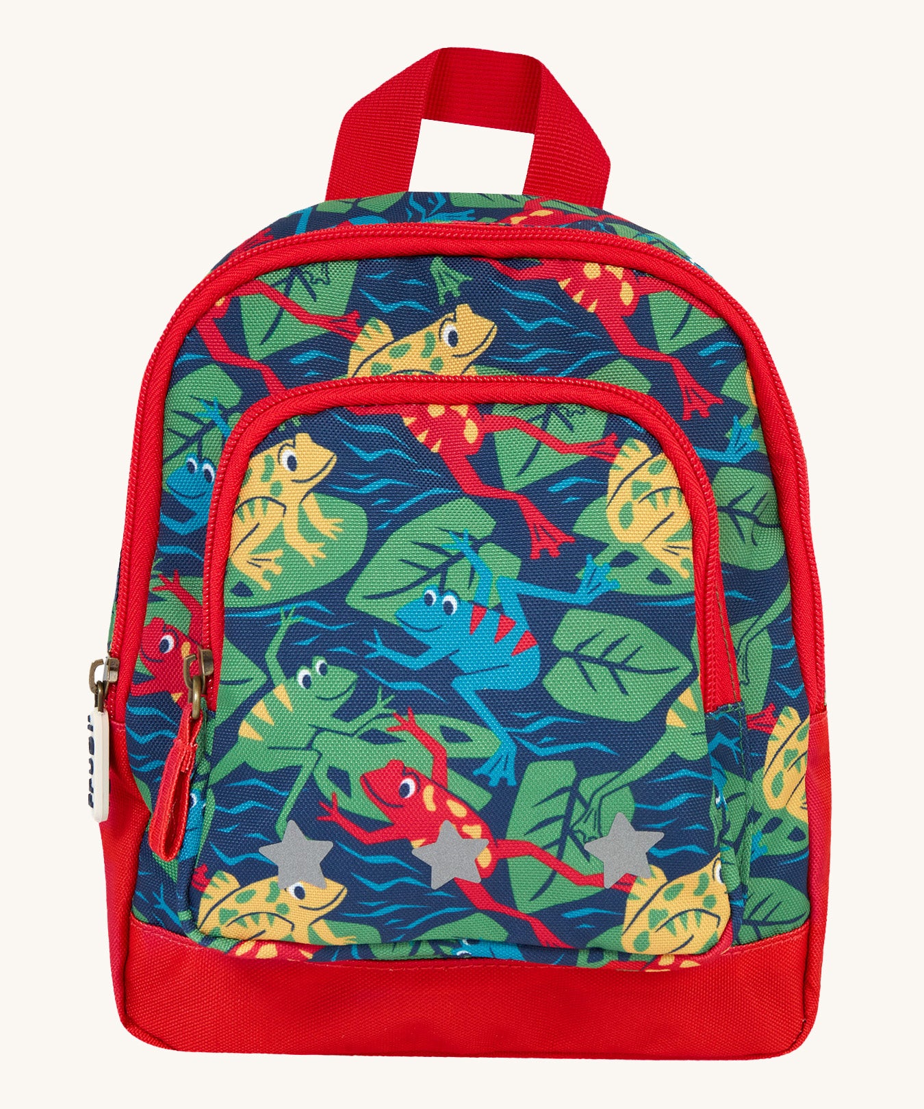 Frugi little adventures backpack in be hoppy. A small navy backpack with red trim and multiple prints of playful frogs. Features 2 compartments and reflective stars