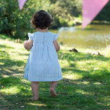 Child wearing the Frugi  Beach Hut Blue Stripe Birdie Body Dress showing the back of the dress