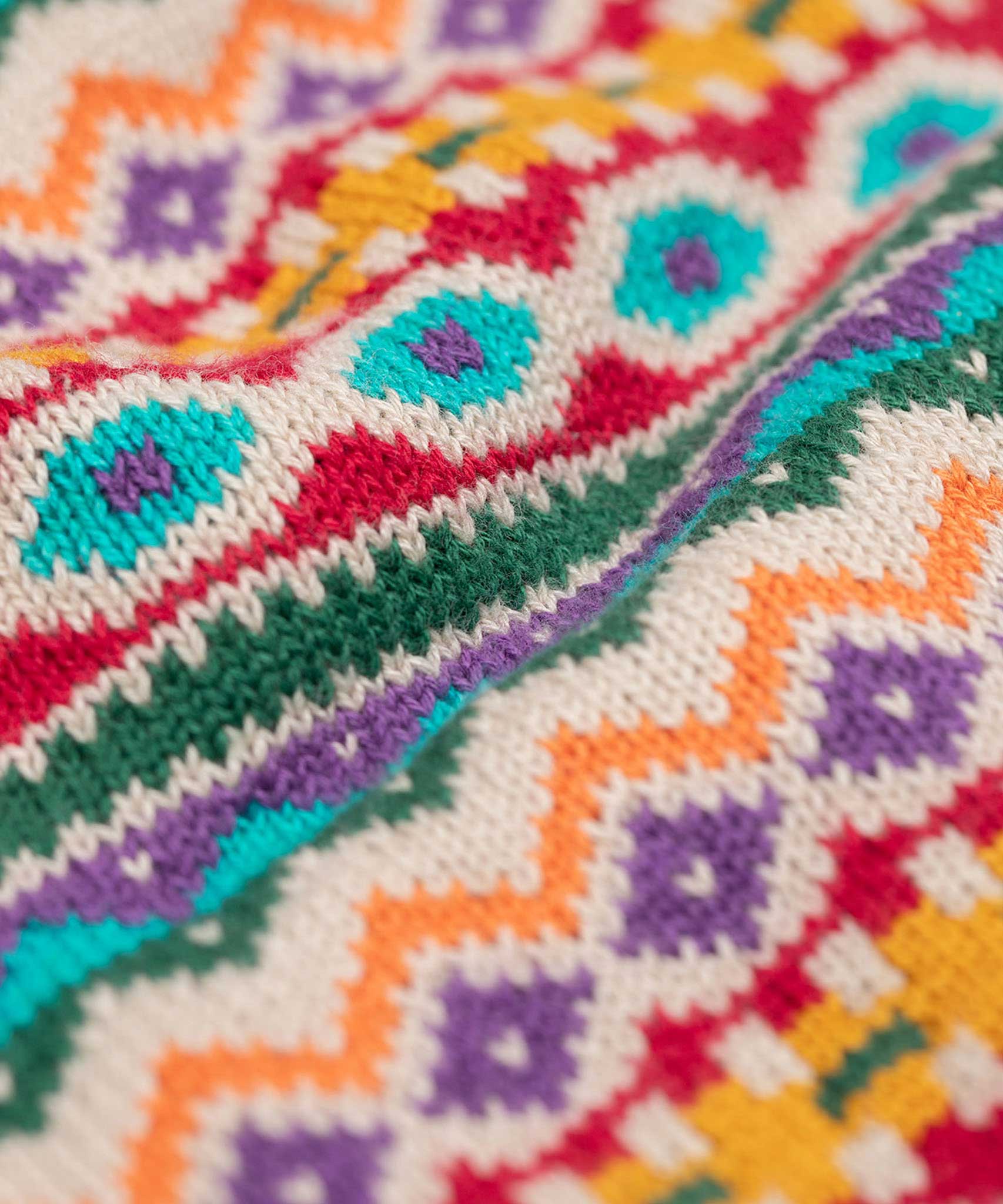 A super close up view of the fair isle print on the Frugi fowey bear fairisle organic cotton knitted jumper.