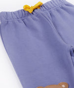 A close up of the yellow gold coloured waist tie on the Frugi bear character grape purple coloured children's crawlers.