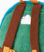 A close up of the  Frugi kids beary wild backpack. Showing the brown corduroy shoulder straps on the green fleece back panel with the name patch stitched in between. 
