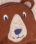 A close up of the  Frugi kids beary wild backpack. Showing the brown corduroy brown bear face detail - features a neutral colour nose trim