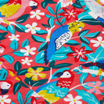 A close up of Frugi Morwenna Skater Dress in the Birds Of Paradise print. Featuring different exotic birds surrounded by colourful flowers and leaves.
