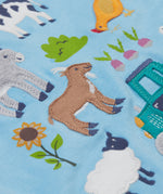 A close up of the Frugi kids bluebird farm life t-shirt  showing the cow, donkey, hen, goat, sheep, goose, tractor, sunflower, carrot, radish and a beetroot appliqué on light blue organic cotton fabric. 