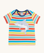Frugi Bobster Applique T-Shirt in a Sea Rainbow Stripe print laid flat, featuring an embroidered Shark in the centre, and popper fastenings at the top.