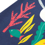 A close up of Frugi Bonnie Dress in Navy Blue, featuring a Sealife print, which includes small fish, surrounded by colourful seaweed and coral.