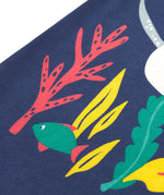 A close up of Frugi Bonnie Dress in Navy Blue, featuring a Sealife print, which includes small fish, surrounded by colourful seaweed and coral.
