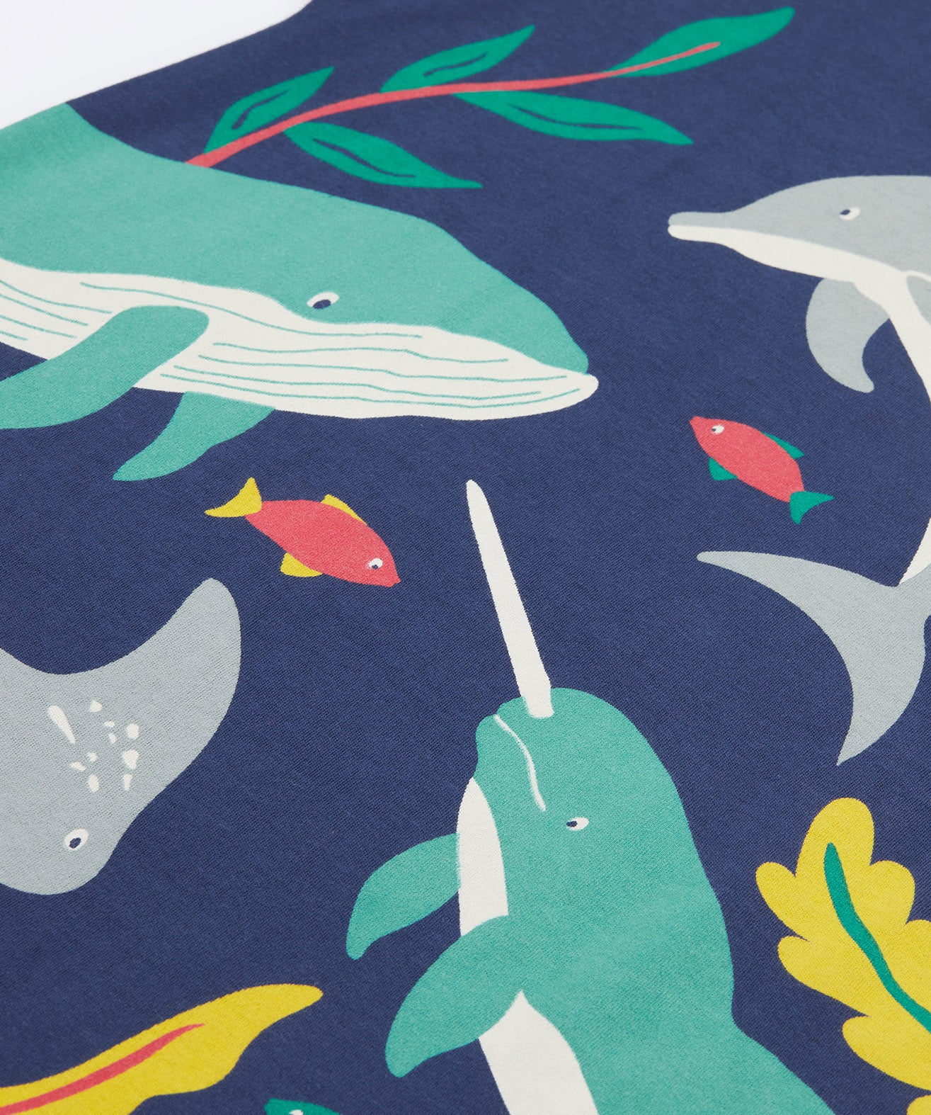 A close up of Frugi Bonnie Dress in Navy Blue, featuring a Sealife print, which includes small fish and larger sea animals, surrounded by colourful seaweed and coral.