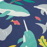 A close up of Frugi Bonnie Dress in Navy Blue, featuring a Sealife print, which includes small fish and larger sea animals, surrounded by colourful seaweed and coral.