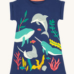 Frugi Bonnie Dress in Navy Blue laid flat, featuring a Sealife print, which includes large sea animals and smaller fish, surrounded by colourful seaweed and coral.