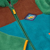 A close up of the Frugi kids braken fleece cord jacket in holly green/hotchpotch showing the diamond shaped patch on the chest and full length zip detail