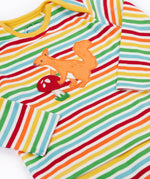 A close up of the top from the frugi kids brooke easy dressing baby grow in squirrel/rainbow stripe showing the squirrel applieque detail on rainbow striped organic cotton fabric.