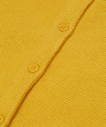 A close up of the Frugi yellow organic knitted cotton cardigan which features yellow buttons