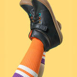 A child wearing the Frugi cape stretch children's lace boot in black leather with salamander orange leather lining. 