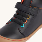 A close up of the coloured eyelets on the Frugi cape stretch children's lace boot in black leather with salamander orange leather lining. 