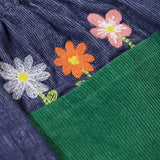 A close up of the embroidered flowers above the back pocket of the Frugi Cara cord children's skirt in ink blue.
