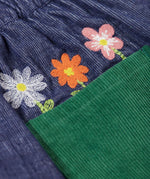 A close up of the embroidered flowers above the back pocket of the Frugi Cara cord children's skirt in ink blue.