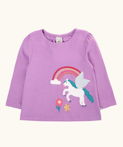 Frugi organic cotton periwinkle purple caris pegasus child's top. White pegasus applique with rainbow and flowers on a lilac long sleeved top.