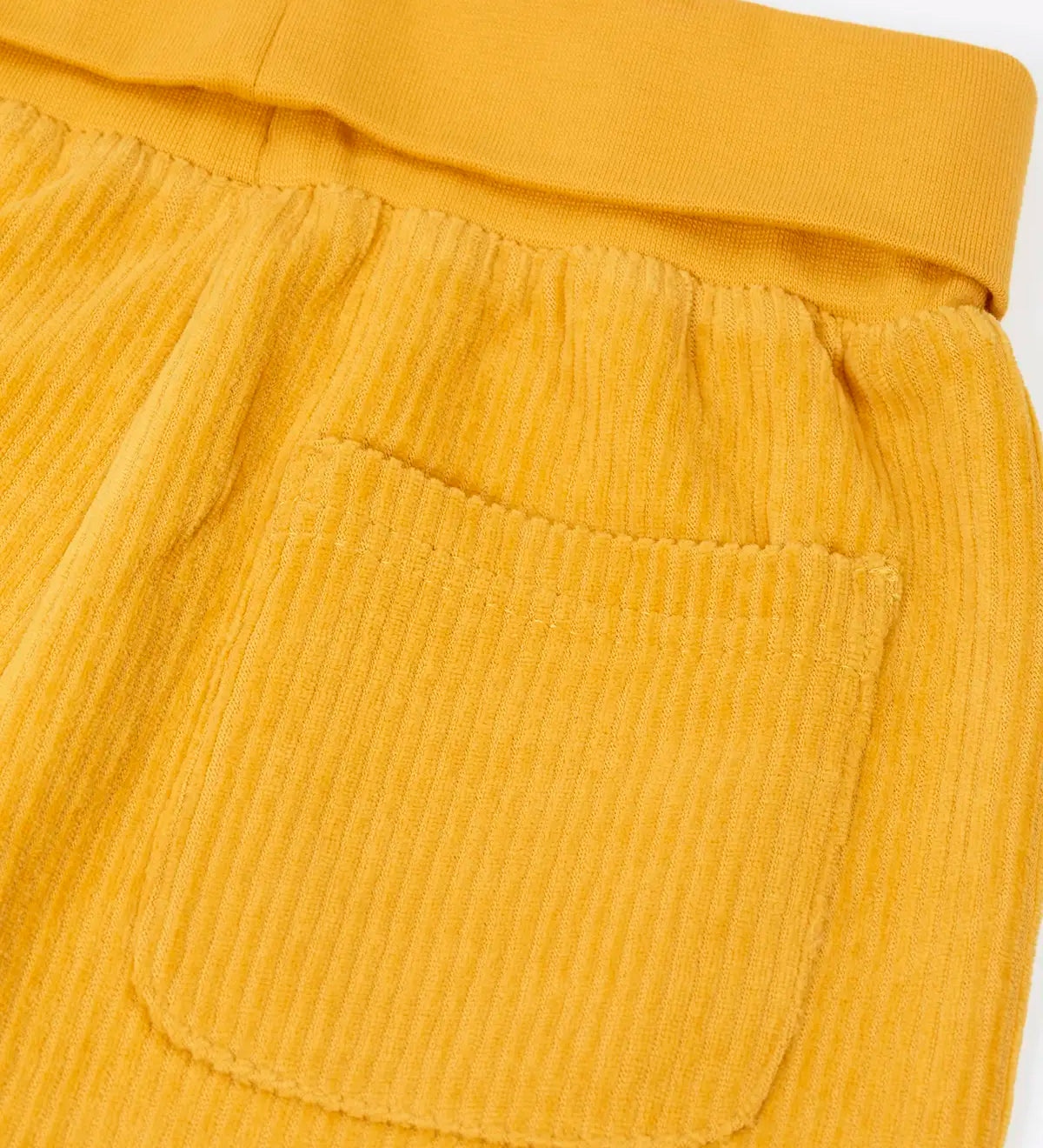 Close up of the back pocket on the Frugi carne organic cotton cord pull up trousers in bumblebee yellow with soft cotton waistband and cuffs that can be folded down for extended wear.