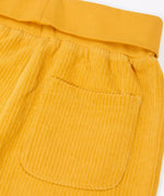 Close up of the back pocket on the Frugi carne organic cotton cord pull up trousers in bumblebee yellow with soft cotton waistband and cuffs that can be folded down for extended wear.