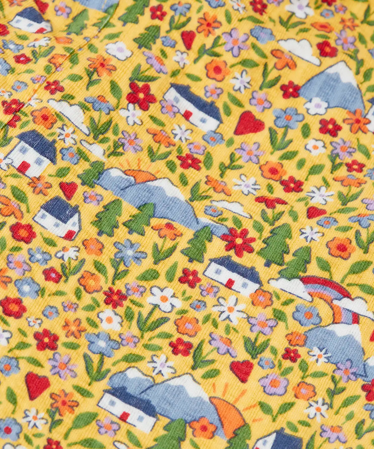 Frugi reversible dungarees showing a close up of the repeating highland cottage print on yellow organic cotton fabric