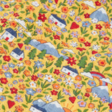 Frugi reversible dungarees showing a close up of the repeating highland cottage print on yellow organic cotton fabric
